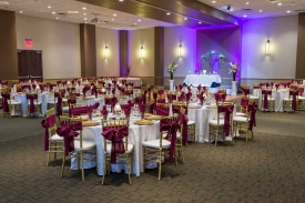 Red Oak Ballroom in Austin, chiavari chairs with ties, plate chargers, stage with head table and arch